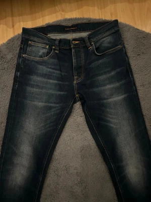 Nudie jeans  - Säljer dessa sjukt feta Nudie jeans. Fint skick. Sjukt snygg tvätt. Modellen är Grim Trim. Storlek 34/36 men de är lite små i storleken så sitter mer som 34/34. Passar dig som är 188-2 m. Hör av dig vid minsta lilla fundering! 