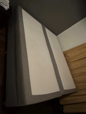 Två gråa sängbottnar - Säljer två sängbottnar i grått tyg med vita ovansidor. Perfekt om du vill bygga en dubbelsäng eller använda dem separat. Raka former och stilren design som passar i de flesta sovrum. Materialet är textilklätt och ger en modern känsla.