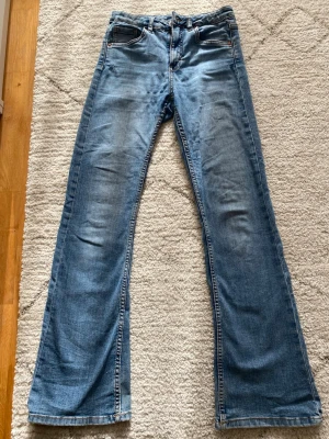 Blå bootcut jeans med utsvängda ben - Snygga blå jeans med bootcut-modell och utsvängda ben från Kappahl. Storlek 158, XS. Dem är använda en hel del men inte trasiga på något sett. Materialet är denim i bomull. Slönt material och fin passform. Perfekta vardagsjeans.