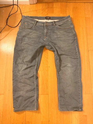 Grå jeans från Armani - Snygga grå armani jeans med raka ben och klassisk femficksmodell. Jeansen har kontrastsömmar och patch med logga bak i midjan. Tillverkade i mjukt denimtyg som ger en avslappnad look. Perfekta för dig som gillar stilrena och tidlösa jeans.