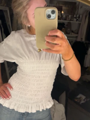 Vit smockad topp  - Säljer en söt vit topp med smockad midja🤍 från Nelly