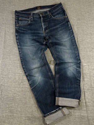 Lee Daren Zip Fly W30 L32 🤍 mid blue wash with insane natural whiskering - These have been worn and used — fading and character are part of the vibe. If you want dark & crisp, skip.  Measurements (flat): waist 40 cm, rise 23 cm, thigh 25.5 cm, inseam 73.5 cm, leg opening 17 cm, backside 45 cm.  Slim straight fit with slight taper. Clean everyday denim. Fits approx women’s EU 38–40 depending on fit preference. See measurements 