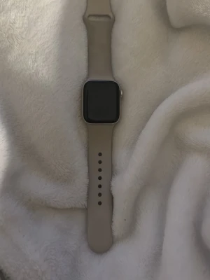 Apple Watch med beige silikonarmband - Apple Watch som är använd ett få antal gånger, jättebra skick och funkar alldeles utmärkt. Passar för den som vill ha en tränings klocka, vanlig klocka och kolla bilder och spela spel i klockan😁👍🏻