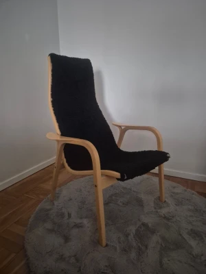 Lamino fåtölj Swedese svart fårskinn - Säljer en Lamino fåtölj från Swedese, designad av Yngve Ekström. Fåtöljen har en stomme i ljust böjträ och är klädd i svart fårskinn. Klassisk skandinavisk design som passar perfekt i alla rum.