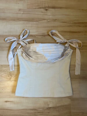 Murlong Crés Korsett topp - Supersöt beige korsettopp med satin band från Murlong Crés. Endast provad och i helt nytt skick. Ny pris: Ca 3000 kr. Pris kan diskuteras! 