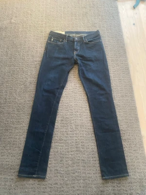 Abrecombie straight fit jeans - Säljer ett par mörkblå jeans med rak passform och klassisk femficksdesign. Jeansen har normal midja och kontrastsömmar. Materialet är denim i bomull. Perfekta för en avslappnad och stilren look.