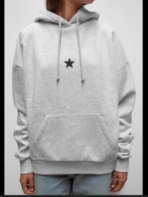 Grå hoodie med stjärna - Snygg grå hoodie med stjärna broderad på bröstet. Hoodien är från subdued, aldrig använd. Orginalpris 699