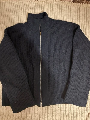 Svart stickad ziptröja med hög krage - Säljer en svart stickad tröja med dragkedja och hög krage. Passar med mycket och funkar för varje årstid.