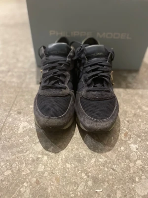 Philippe Model mörkblå sneakers - Säljer mina mörkblå Philippe model skor med silvriga detaljer och vit sula. Det finns också vita skosnören till, men dom är använda. Dom är i väldigt bra skick. Och dom är ganska stora i storleken så dom passar på storlek 39 också