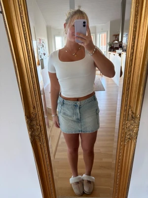 Ljusblå jeanskjol med fickor - Trendig ljusblå jeanskjol i minilängd med två stora fickor framtill och dragkedja. Kjolen har en avslappnad passform och klassisk denimlook, perfekt till sommaren. Inga synliga märken eller loggor. Passar dig som gillar en casual och cool stil.