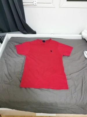 Röd t-shirt från Polo Ralph Lauren - Klassisk röd t-shirt från Polo Ralph Lauren med liten broderad logga på bröstet. T-shirten har rund halsringning och korta ärmar. Perfekt basplagg i mjuk bomull som funkar till det mesta.