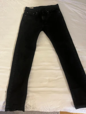  Levi's jeans - Säljer ett par svarta jeans från Levi's med klassisk femficksdesign och röd Levi's-tag på bakfickan. Materialet är mjukt denim med lite stretch för extra komfort. Säljer pga för små 