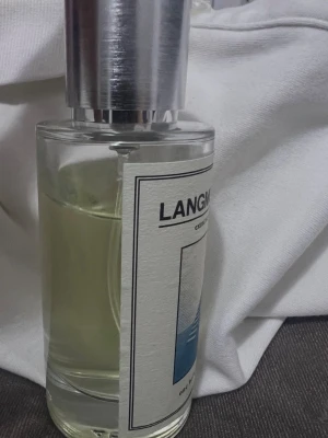Langmuir 17.0 Extrait de Parfum - En stilren parfymflaska från One Bold Chemist med namnet Langmuir 17.0. Flaskan är cylindrisk i klart glas med en silverfärgad kork och en vit etikett med blått motiv. Parfymen har en modern och minimalistisk design som sticker ut i badrumshyllan. Det är typ 38-40ml kvar andvänder it längre.