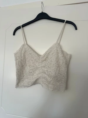 Kort topp med spets - Kort topp/linne med spets och lite scrunch. Dragkedja i sidan. Använd fåtal gånger 