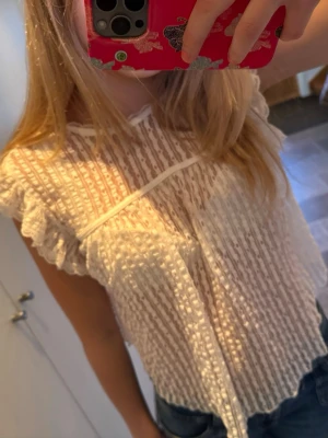 Vit spetsblus med knyte i nacken - Söt vit blus i spets med volangärmar och knytning i nacken❤️ köpte den från Nelly för något år sedan men använt endast fåtal gånger! 