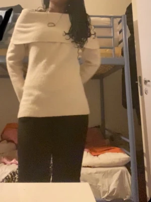 Offshoulder stickad tröja med krage - Säljer en beige stickad tröja med bred, nedvikt krage som ger en snygg och modern look. Tröjan har lång ärm och rak passform, perfekt för lager-på-lager. Mjuk och skön, passar till både jeans och kjol.