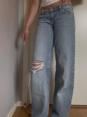 Ljusblåa Gina Tricot jeans  - Säljer ett par super snygga baggy jeans från Gina Tricot. Ljusblåa jeans med fem ficks modellen med slitning på ena knät. Änvänd fåtal gånger! Super fint skick! St 32. Midja mått: 38 innebenslängd: 80. Passar mig som brukar ha st 34❤️ Ny pris 499. 