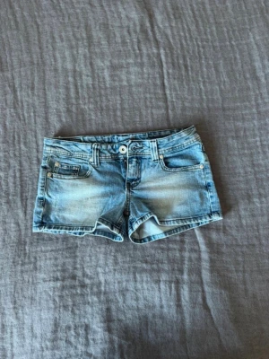 Ljusblå lågmidjade  jeansshorts - Säljer ett par ljusblå jeansshorts från So Jeans med låg midja. Jätteskön passform och material. Perfekta till sommaren och lätta att matcha med olika toppar.