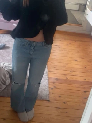 Ljusblå loose jeans med hål  - Säljer ett par ljusblå bootcut jeans med slitningar på knäna. Jättefina och endast använda 1 gång så som nya❣️