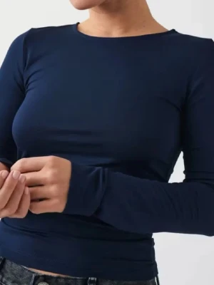Mörkblå långärmad topp Gina Tricot - En enkel och stilren mörkblå långärmad topp från Gina Tricot. Toppen har rund halsringning och är tillverkad i mjuk, stretchig bomullsmix som sitter bekvämt mot kroppen. Perfekt att matcha med jeans eller kjol för en clean look.