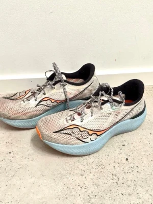 Saucony Endorphin Pro 3, carbonplate - Saucony Endorphin Pro 3, uppdaterad version av denna kolfibersko för tempo, intervaller och tävling för distans upp till marathon. Använd, men det finns bra till och push kvar i plattan. Utökad S-formad kolfiberplatta för kraftfull framåtdrivning, Speedroll-teknologi, mer PWRRUN PB-mellansula (PEBA), FORMFIT-ovandel med tunn mesh och en låg vikt på 215 gram. Jag har 43 på Adidas och 43 1/3 på Asics vilket motsvarar Saucony storlek 44. Skick syns på bilderna.