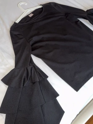 Svart topp med volangärmar - 3 Stycken svarta toppar och alla i strk S eller M. Finns inget fel på dem och är trendiga. Säljer pga för små. Passar alla tillfällen! Alla tre för 190 kr!