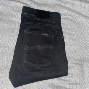 Svarta Nudie Jeans W28 L30 - Säljer ett par Nudie Jeans Lean Dean i svart. De är använda endast ett fåtal gånger utan skador eller slitage. Nypris: 1599 kr. Perfekta för dig som söker stiliga, hållbara och bekväma jeans. Hör gärna av dig om du har några frågor eller liknande🙌