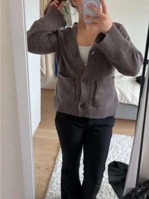 Brun stickad kofta med fickor - Mysig brun stickad kofta från lager 157 med v-ringning och stora knappar framtill. Den har två fickor framtil, kan både kläs upp eller bara användas som en chill kofta att ha hemma💕