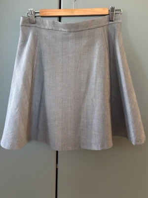 Grå A-linjeformad kjol från Monki - Säljer en stilren grå kjol från Monki i A-linjeformad modell. Perfekt att matcha med både stickade tröjor och t-shirts.