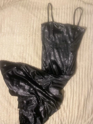 Glitter klänning   - Svart skimrande lång klänning i färgen svart. Har en liten slits på vänster sida. Mjuk material och väldigt skims i passformen.  Sitter som S/Medium size. Använt 1 gång , denna klänning gör vem som helst avundsjuk över dig! Den är  en hand under mina knän och jag är 167cm