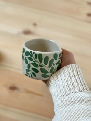 Handgjord keramikmugg med grönt bladmotiv - Matchaskål i keramik – handgjord  Handgjord matchaskål i keramik. Perfekt för att vispa matcha eller som en vacker detalj i köket.  Varje skål är tillverkad för hand, vilket innebär att små variationer och naturliga ojämnheter kan förekomma – det är en del av hantverket och gör varje exemplar helt unikt.  Rekommenderas att handdiskas. Men tål diskmaskin och micro.  Handmade – fruitnclay