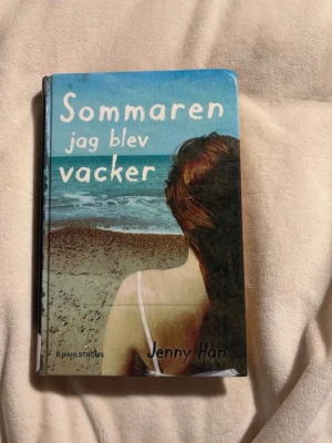 Sommaren jag blev vacker av Jenny Han - En ungdomsroman med hård pärm, blå och beige omslag med strandmotiv. Boken är skriven av Jenny Han och handlar om sommarlov, kärlek och vänskap. Perfekt för dig som gillar romantik och coming-of-age berättelser. Skulle själv säga att den är i väldigt bra skick men kan ha hundöron på vissa sidor !!