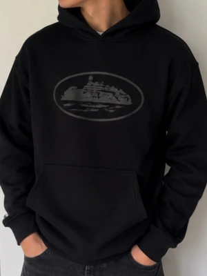 Svart hoodie med tryck av fartyg - Svart hoodie med stor ficka framtill och huva. På bröstet finns ett diskret tryck av ett fartyg inuti en oval ram. Hoodien har en avslappnad passform och är tillverkad i mjukt material, perfekt för en cool och bekväm stil.