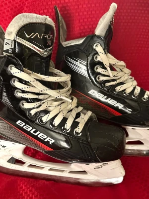 Bauer Vapor X3 ishockeyskridskor st4( 37,5-38) - Säljer ett par svarta Bauer Vapor X3 ishockeyskridskor med vita snören och röda detaljer. Skridskorna har robust konstruktion, Comfort Edge och vita plastskenor. Perfekta för dig som vill ha bra stöd och kontroll på isen.