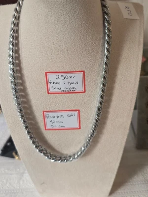Kedjehalsband i rostfritt stål 50 cm - Snyggt halsband i blankt rostfritt stål med grov kedja, ca 10 mm brett och 50 cm långt. Halsbandet har en modern och stilren look som passar till många olika outfits. Perfekt för dig som gillar en lite tuffare accessoar.