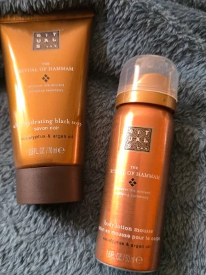 Rituals The Ritual of Hammam duo - Säljer ett set från Rituals The Ritual of Hammam med ultra hydrating black soap (70 ml) och body lotion mousse (50 ml). Båda innehåller eukalyptus och arganolja. Förpackningarna är kopparfärgade med bruna och guldiga detaljer.