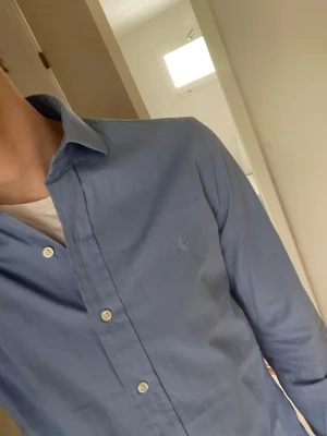Blå skjorta från Ralph Lauren - Ralph lauren skjorta! Storlek S/ 32/33! Modellen är slim fit och sitter väldigt bra! Personen på bilden är 184 cm, väger ca 70kg! Modellen passar 177-187cm! Hör av er vid minsta fundering!