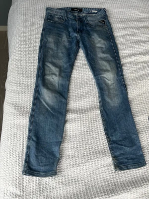 Blå slim fit jeans från Blend - Snygga blå slim fit jeans från Blend med klassisk femficksmodell och slitningar på låren. Jeansen har dragkedjegylf och detaljerade sömmar på bakfickorna. Tillverkade i mjuk denim med lätt tvättad look.