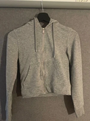 Basic zip up hoodie - Grå zip up hoodie från H&M. Använd men i mycket fint skick, inga hål, fläckar eller andra anmärkningar.