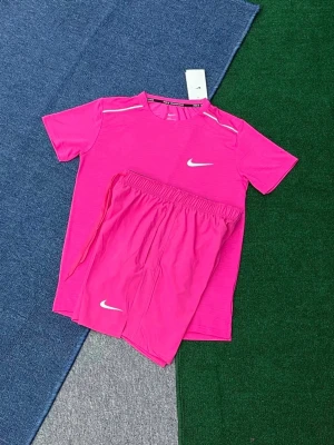 Rosa nike Miller  från Nike  - Snyggt rosa träningsset från Nike med t-shirt och shorts. Setet har vita Nike-loggor på både tröjan och shortsen samt diskreta vita detaljer på axlarna. Perfekt för träning eller sportaktiviteter. Tillverkat i lätt och snabbtorkande material.