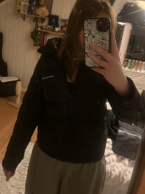 Svart pufferjacka från Peak Performance - Snygg svart pufferjacka från Peak Performance. Perfekt för våren då den inte är jättetjock. Framtill dragkedjan har tappat sin grej på men dragkedjan funkar utan problem!