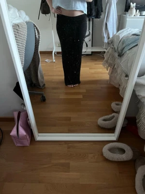 Svart långkjol i stretchigt tyg - Säljer en svart långkjol med enkel och stilren design. Kjolen har en tight passform och är gjord i ett stretchigt material som sitter snyggt längs kroppen. Perfekt att matcha med crop tops eller stickade tröjor.