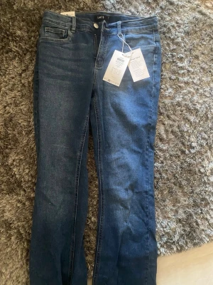Blå bootcut jeans från LMTD - mörkblå bootcut jeans från LMTD i medium blue denim. Stl EU 164, passar ca 14 år.
