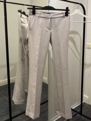 Low waist kostymbyxor - Lågmidjade kostymbyxor med bootcut från bikbok. Sitter otroligt fint på. Aldrig använda bara provade. Stl 34, normal längd, ljust beiga. Kan skickas / hämtas :)