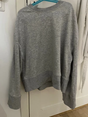 Grå oversized sweatshirt - En enkel och stilren grå sweatshirt med oversized passform. Tröjan har rund halsringning, långa ärmar och breda muddar vid ärmslut och nederkant. Perfekt för en chill och avslappnad look.