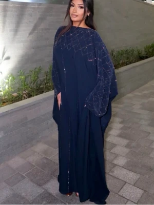 Abaya - navy med lite glitterdetaljer elegant abaya -  fjärilsabaya med ett innerbälte för att knyta åt midjan om så önskas. Handgjorda stenar är täckta över hela abayan. Detta är den perfekta snygga men ändå blygsamma abayan att lägga till i din samling! (Alla lyxabayas levereras med en matchande halsduk och är handgjorda i UAE) Elegant  abaya med glittriga detaljer och glänsande i mörkret och ljus. Klänningen har vid passform och långa, flödande ärmar som ger en lyxig känsla. Storlek:58 baserat på längden 170-173, falsk storlek nedanför (40)