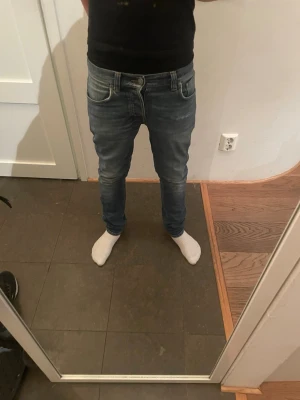 Blå slim jeans med slitningar - Jag säljer ett par riktigt snygga slim fit nudie jeans i storleken L30 W28. Dom har riktigt schyssta fades och är i väldigt bra skick. Jag är 172 och de sitter perfekt på mig, men de hade nog passat bra på alla mellan 168-173. De är perfekta för dig som vill ha ett par snygga jeans inför sommaren! Skriv kring frågor! (Priset kan diskuteras)