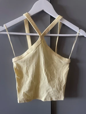 Ljusgul ribbad linnetopp Gina Tricot - Säljer en ljusgul ribbad linnetopp från Gina Tricot i modellen Lilo. Toppen har smala axelband.