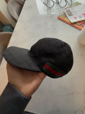 Svart Gucci keps  - Svart gucci keps i storlek S, kan mötas upp i göteborg och även fraktas tillbehöret jag har till kepsen ärr dustbag har ingen box till den skriv om en intresse