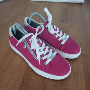 Rosa sneakers från Rieker - Snygga rosa sneakers från Rieker med vita snören och dragkedja på sidan. Skorna har blivit färgade med det gpr absolut att fixa om man har en impregneringsspray.